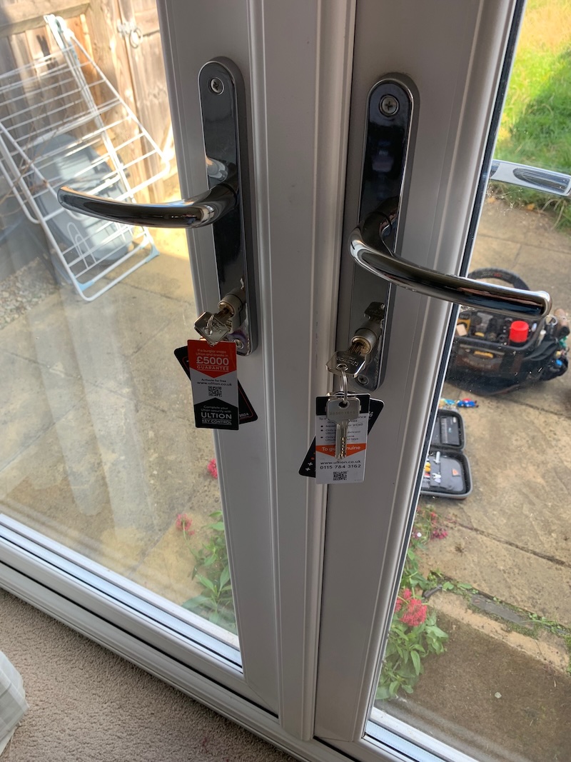 A professional locksmith demonstrating the difference between a standard lock and an anti-snap lock in Oxfordshire.